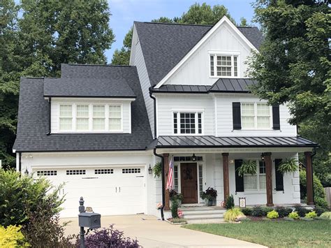 6 black gutters on white house with black metal roof|are black gutters more expensive.